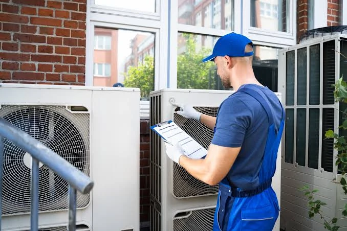 Technician inspecting outdoor HVAC equipment with a maintenance checklist
