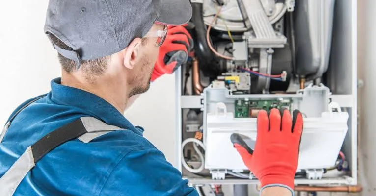 Technician inspecting the internal controls of a heating system